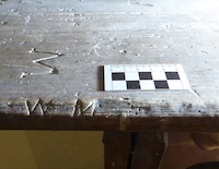 Initials on wooden bench in gallery